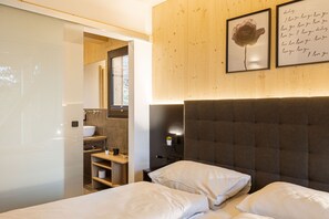 Ein Schlafzimmer mit einem Bett, einem Nachttisch, einer Wandlampe und einem gerahmten Bild.