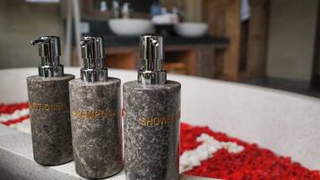 Three cylindrical bottles with pump dispensers labeled "Conditioner," "Shampoo," and "Shower Gel" on a countertop.