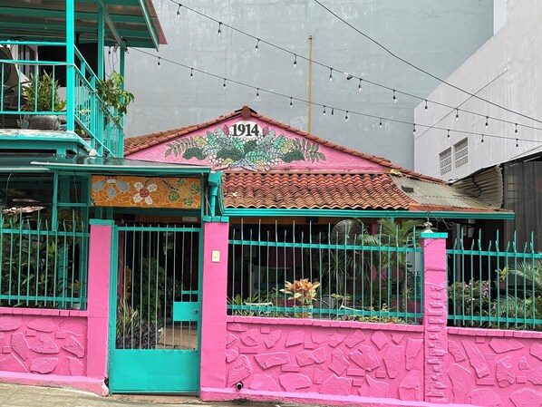 A house with a pink exterior, a tiled roof, and a number '1914' on the front. - Posada 1914 (Panama City)