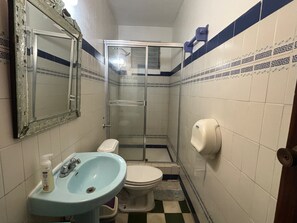 A small bathroom with a sink, toilet, and shower. - Posada 1914 (Panama City)
