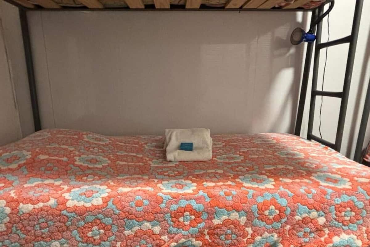 A bunk bed with a floral-patterned mattress and a small pillow.