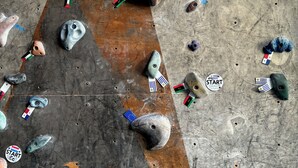 A climbing wall with various holds marked with different national flags. - Posada 1914 (Panama City)