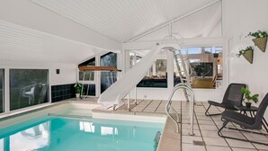 An indoor swimming pool with a slide, a sunbed, and a seating area with chairs. - "Annlisa" - 1km from the sea by Interhome (Blokhus)