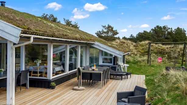 A modern house with a wooden deck, outdoor seating, and a glass conservatory. - "Annlisa" - 1km from the sea by Interhome (Blokhus)