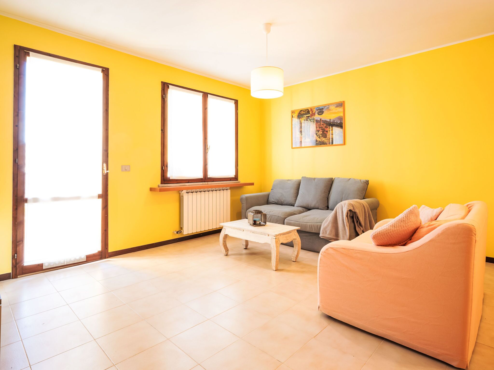 A living room with a sofa, a coffee table, and a radiator.