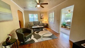 A living room with a sofa, armchair, coffee table, and a decorative rug.