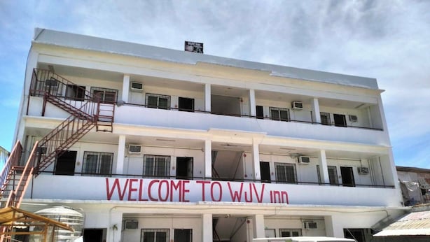 A multi-story building with a sign reading "WELCOME TO WUV Inn". - Wjv Inn Pusok (Lapu-Lapu)