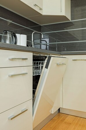 Comfort appartement | Privékeuken | Een koelkast met diepvriezer, een microgolfoven, een oven, een kookplaat