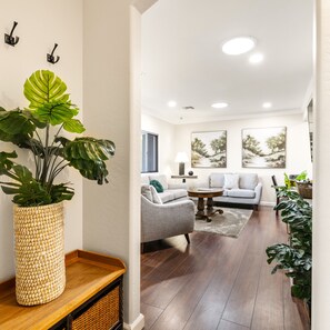 A modern living room with a large potted plant, a sofa, and a coffee table. - Prescott Family Friendly 3 Bedroom w Large Yard (Prescott)