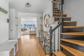 Un interior moderno con una escalera, vistas al exterior y un comedor.