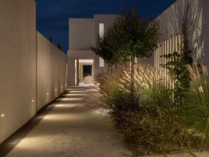 A modern building with a narrow pathway leading to an entrance. - Butterflies Luxury Estate (Zakynthos)