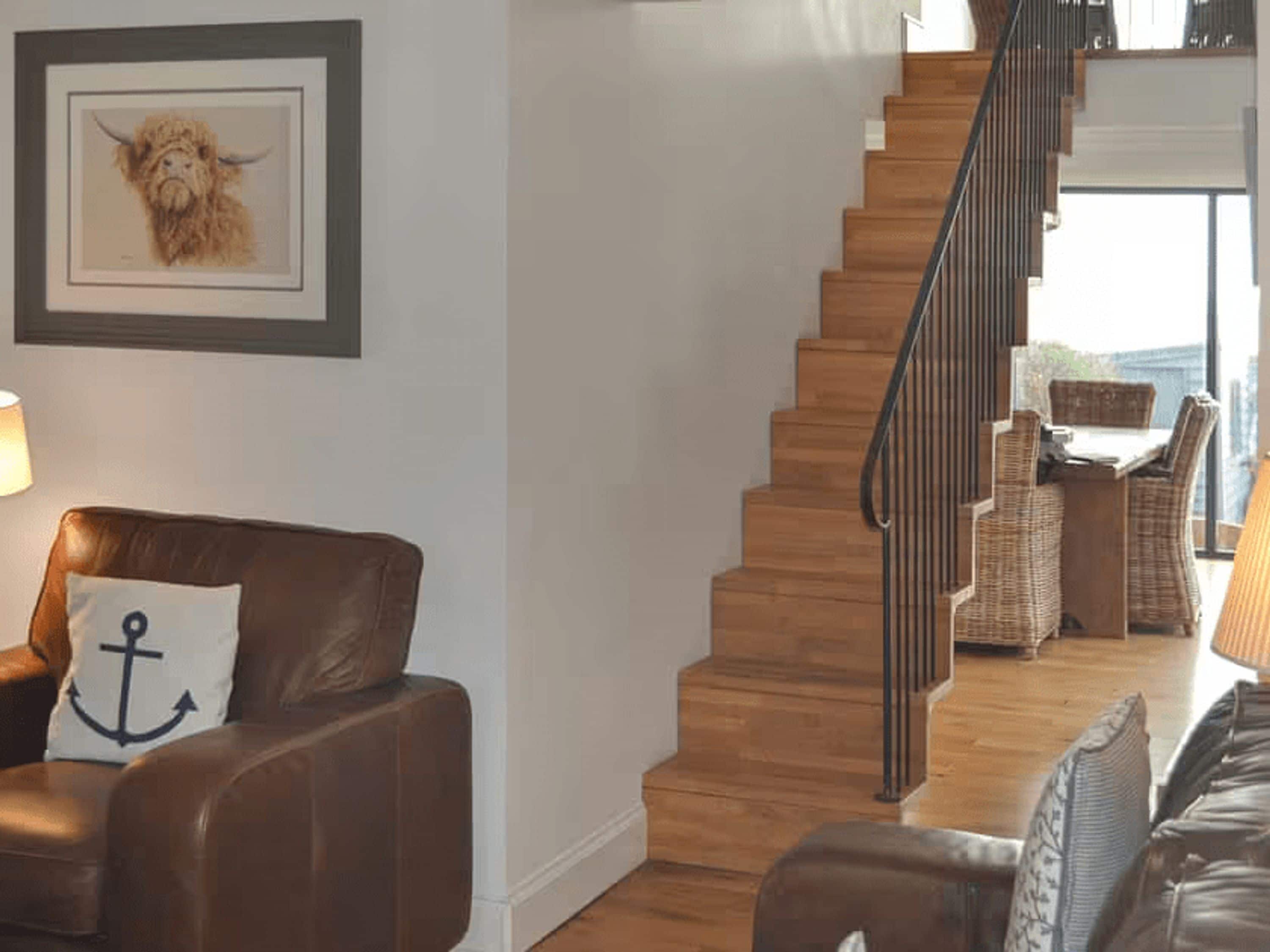 A staircase with wooden steps and a metal railing leading to a balcony.