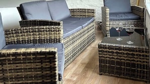 A cozy attic room with wicker furniture, a wooden floor, and a sloped ceiling. - Timco apartment with lake view (Torno)