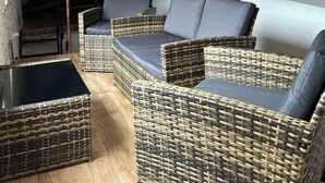 A rustic interior with wicker furniture and a wooden beam ceiling. - Timco apartment with lake view (Torno)