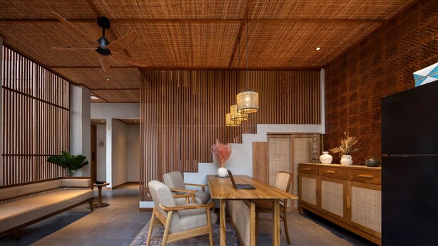 Une cuisine moderne avec une table en bois, des chaises et un réfrigérateur noir.