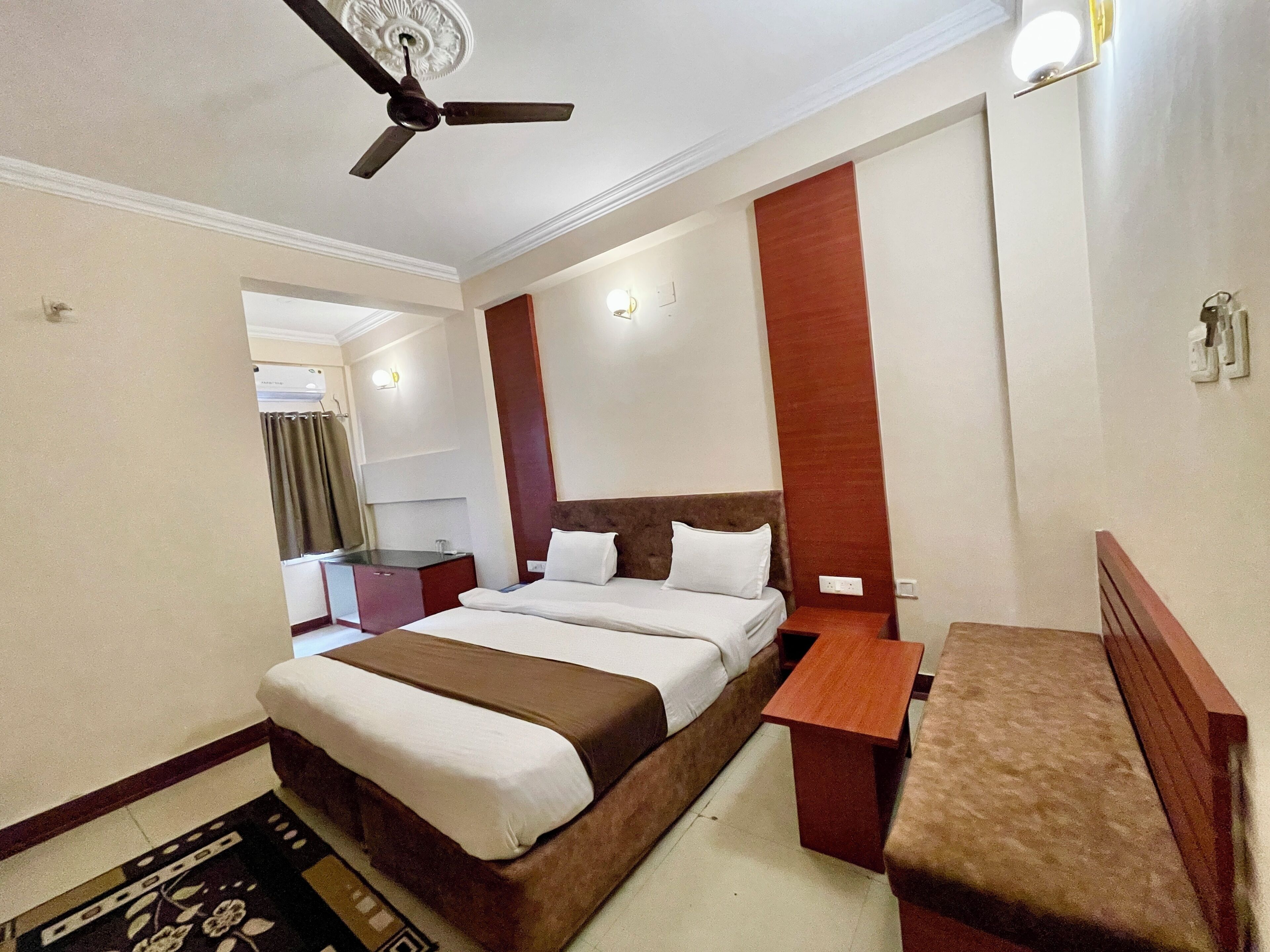 A hotel room with a bed, bedside table, and a ceiling fan.