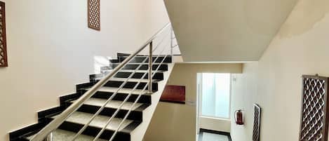 A staircase with metal railings and a fire extinguisher on the wall.