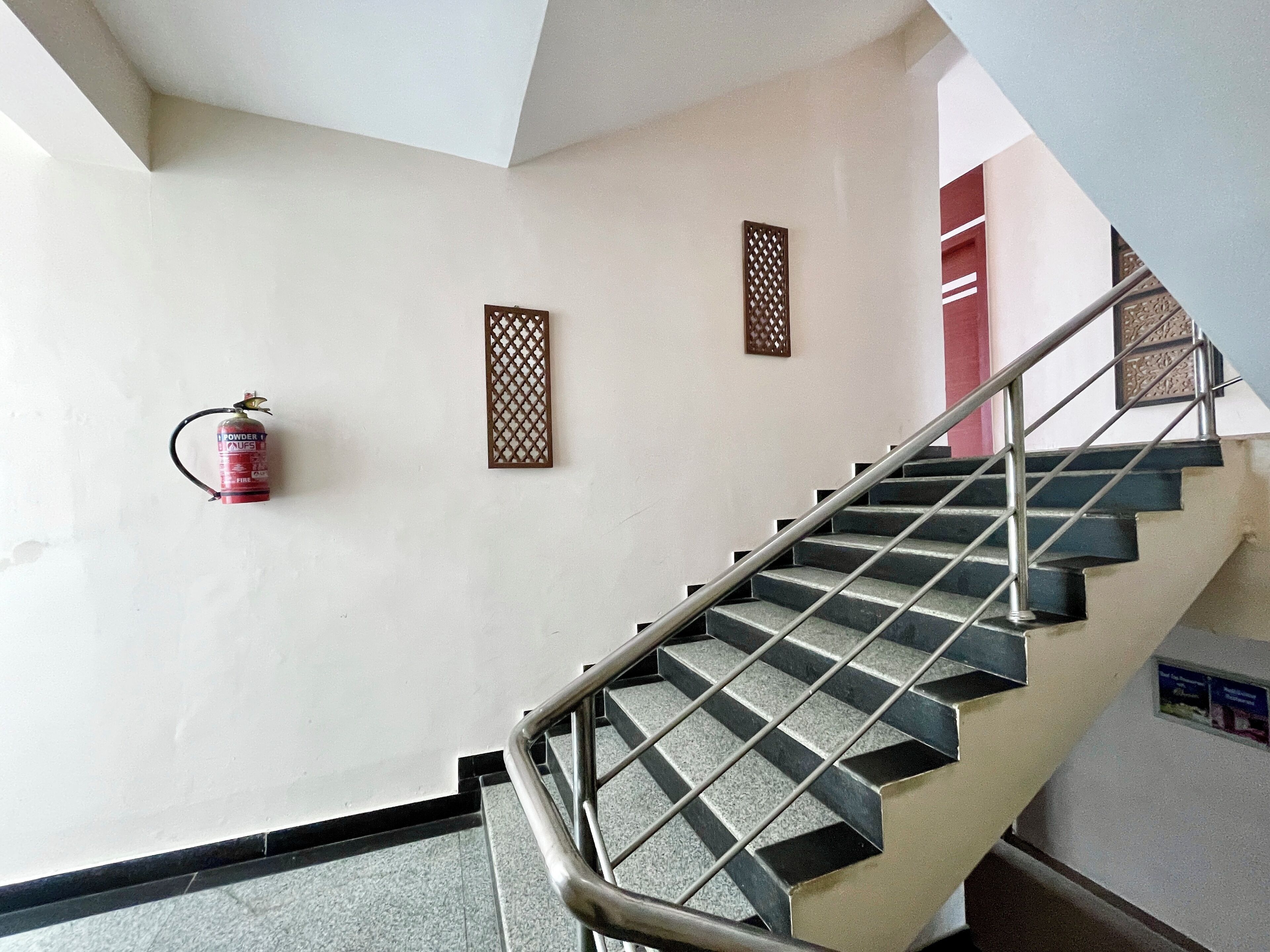 A staircase with metal railings and a fire extinguisher mounted on the wall.