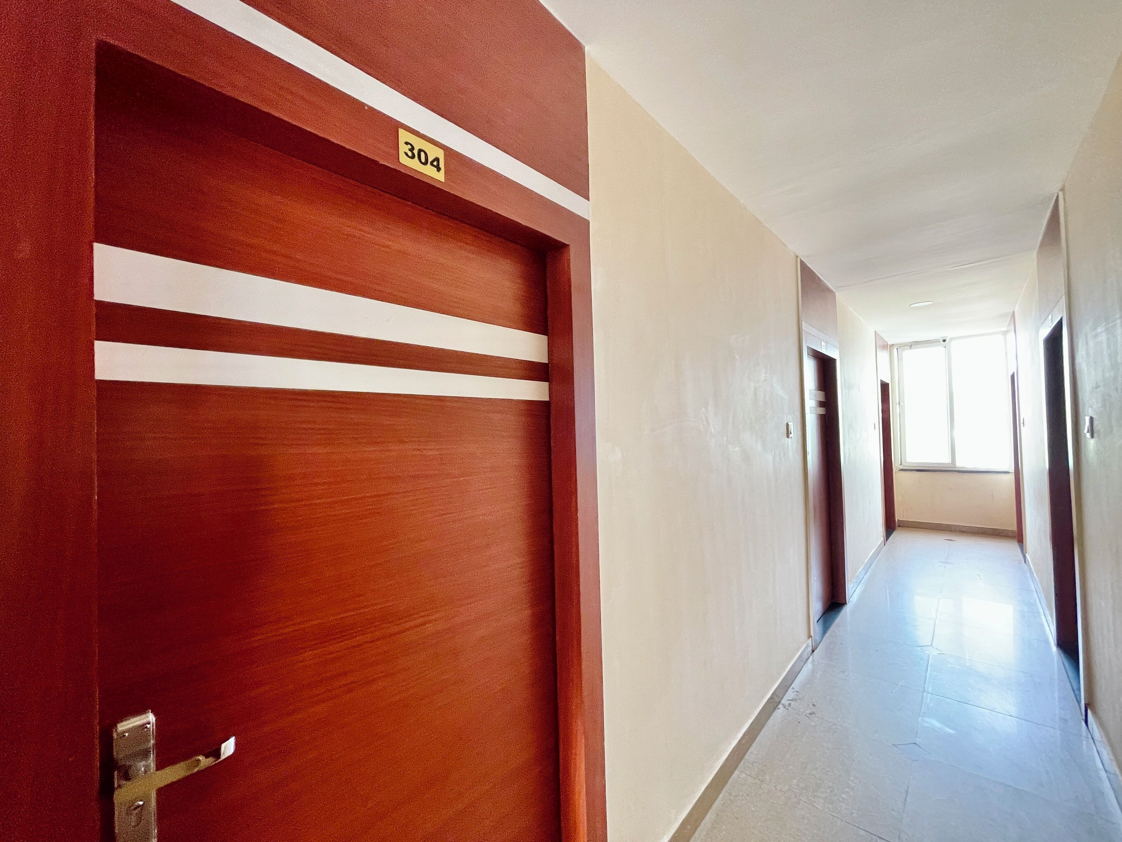 A corridor with a wooden door marked '304' and a tiled floor.