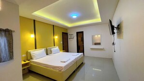 A hotel room with a bed, bedside table, nightstand, and a ceiling light. - Casanova Inn (Bamban)