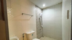 A bathroom with a toilet, bidet, and shower. - Casanova Inn (Bamban)