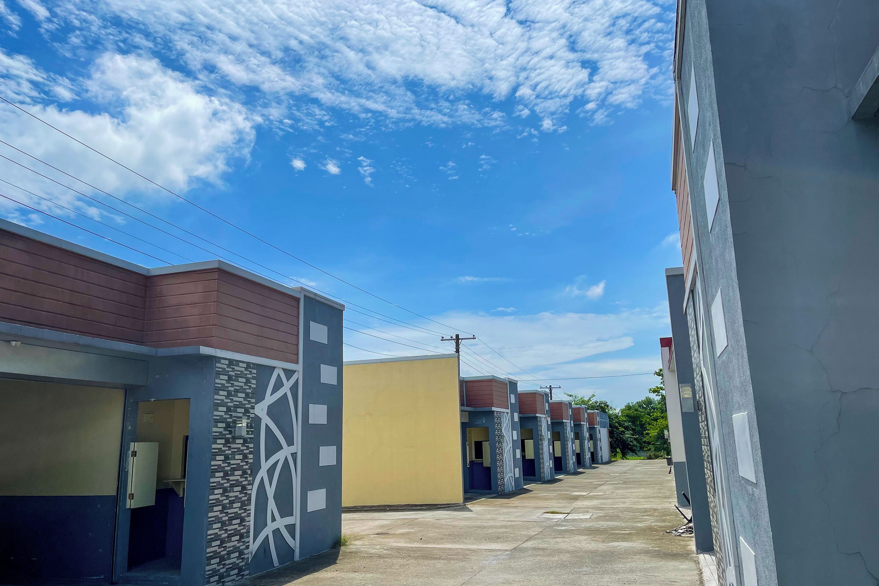 A row of modern, multi-story buildings with a mix of architectural styles, including geometric patterns and plain surfaces.