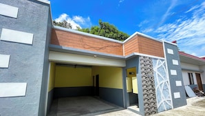 A modern building with a garage entrance, a covered walkway, and a small balcony. - Casanova Inn (Bamban)
