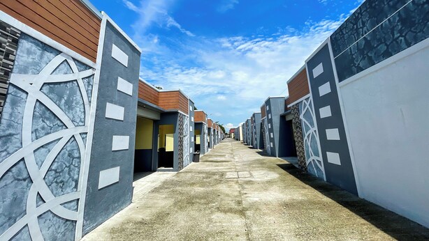 A corridor with modern buildings, a clear sky, and a concrete floor. - Casanova Inn (Bamban)