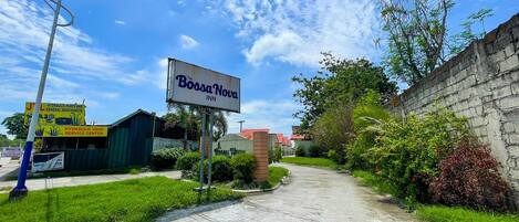 A road leading to Bossa Nova Inn with a clear sky.