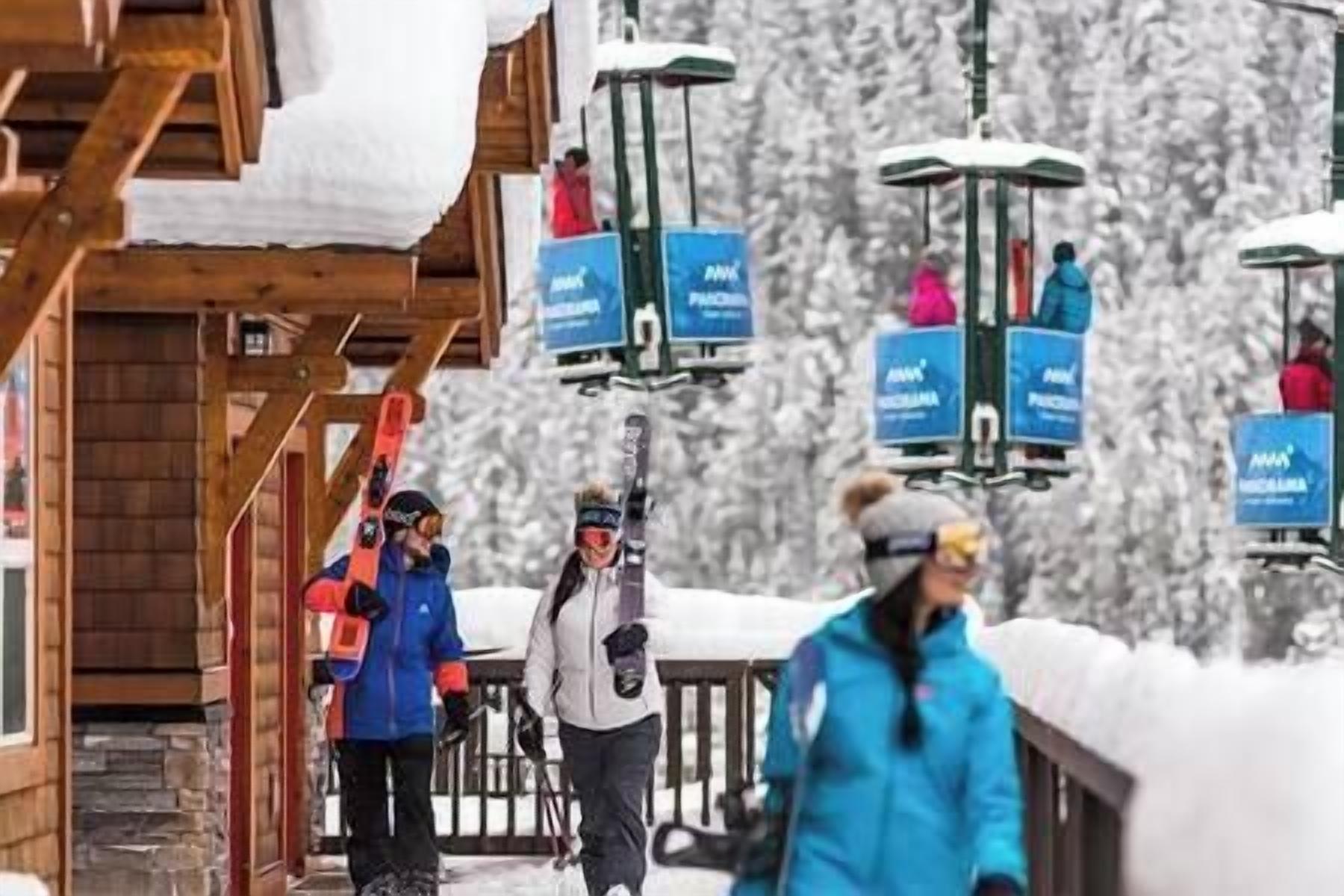 Ein Skigebiet mit Holzbauten und schneebedeckter Landschaft.