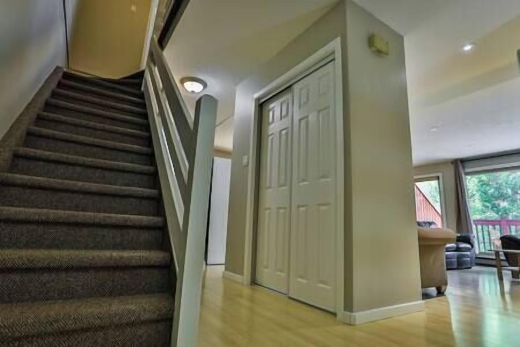 A staircase leading to a room with a closet and a window.