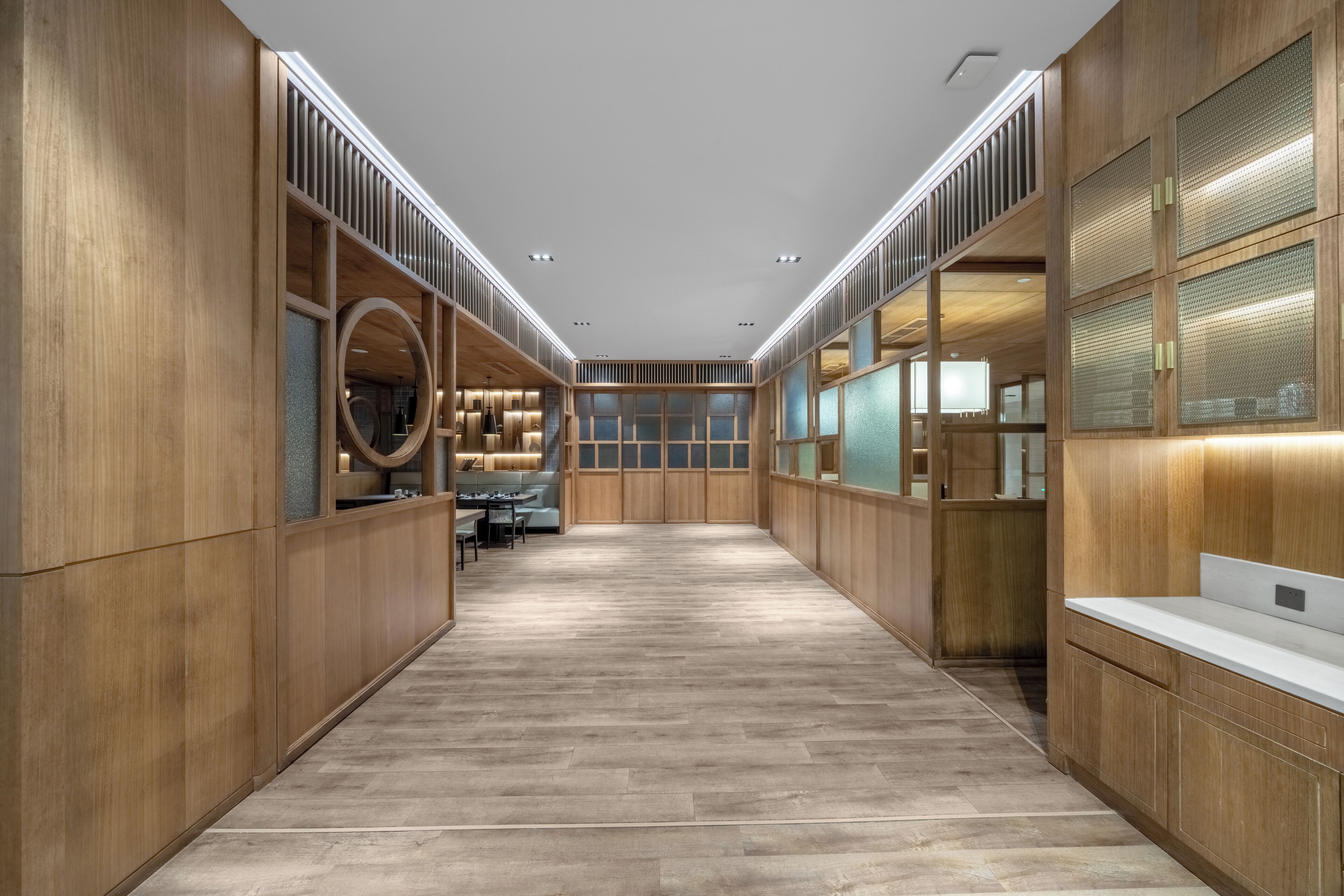 A modern, spacious hallway with wooden paneling and a central seating area.