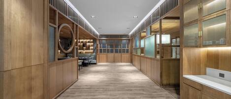 A modern, spacious hallway with wooden paneling and a central seating area.