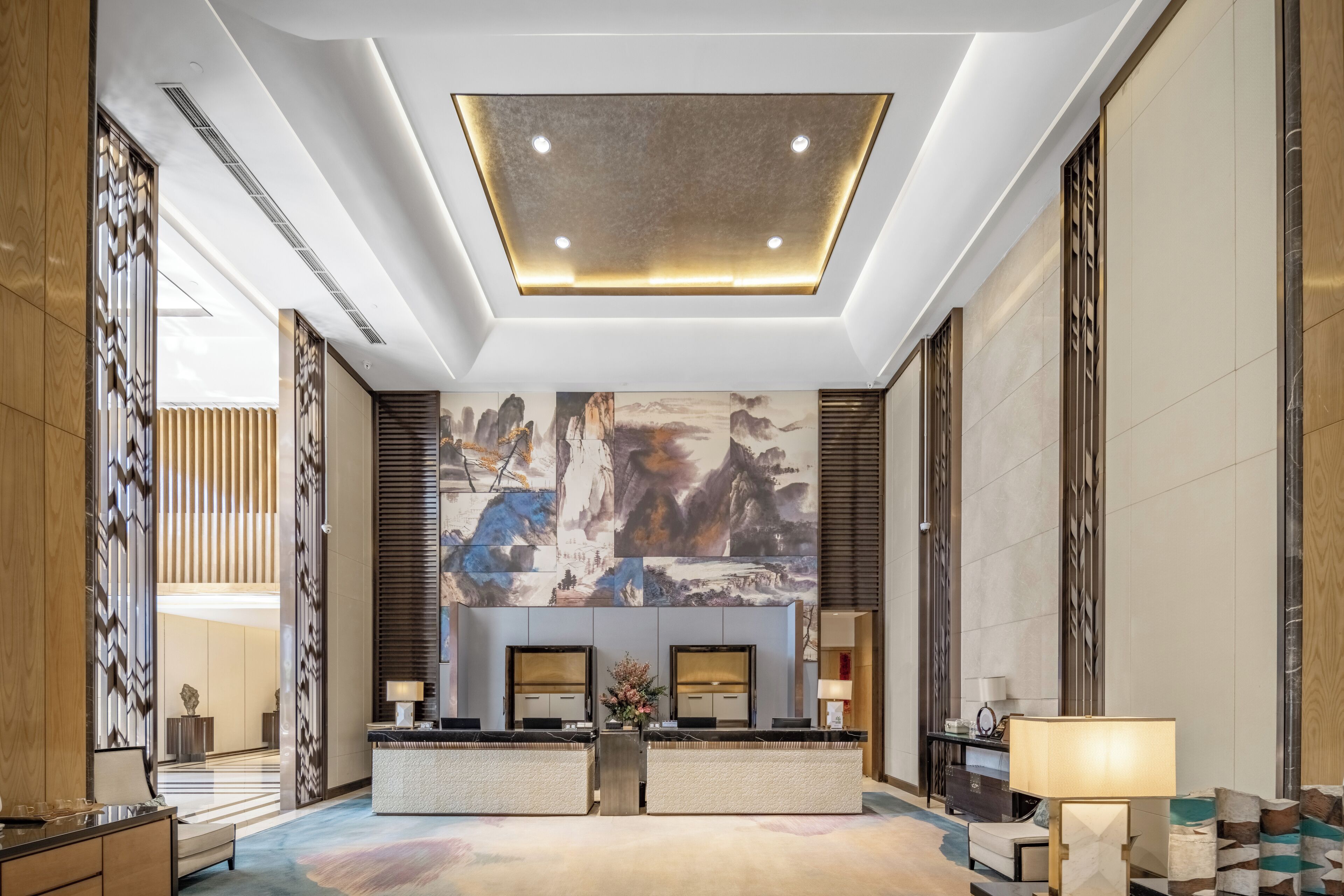 Un hall de hotel con una recepción, zona de estar y obras de arte en la pared.