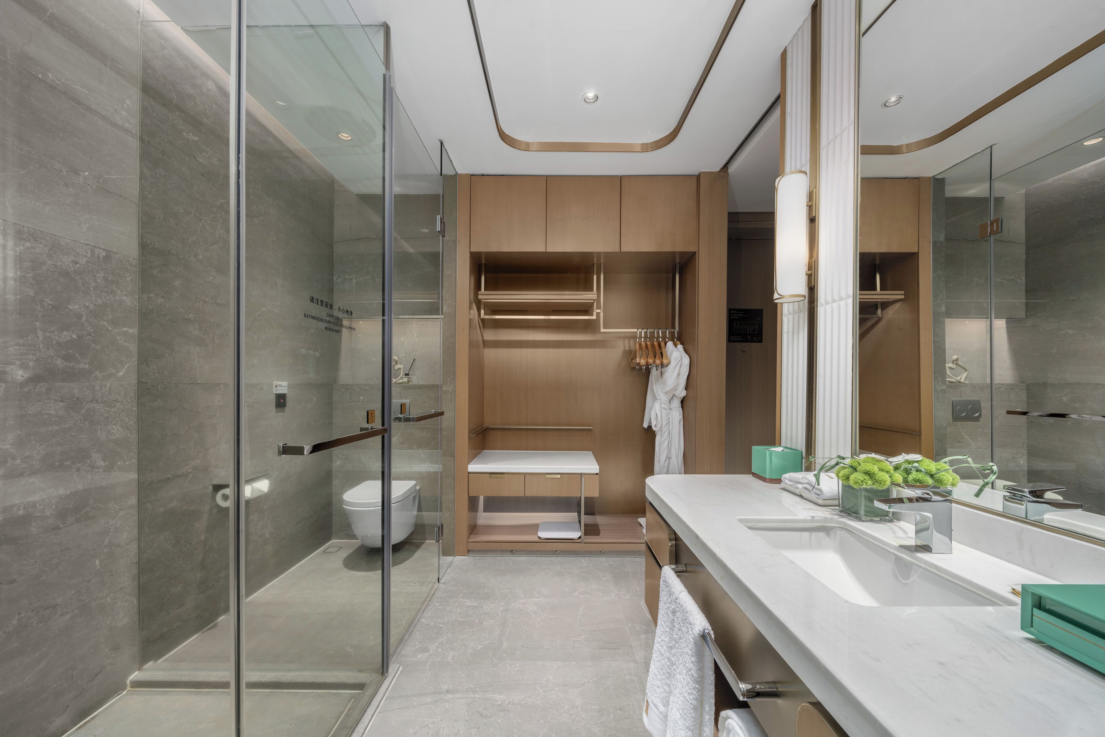 A modern bathroom with a glass shower enclosure, a vanity with a mirror, and a built-in bench.