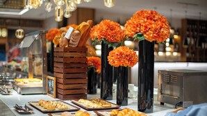 Un buffet proposant une variété de produits de boulangerie et décoré de fleurs d’oranger.