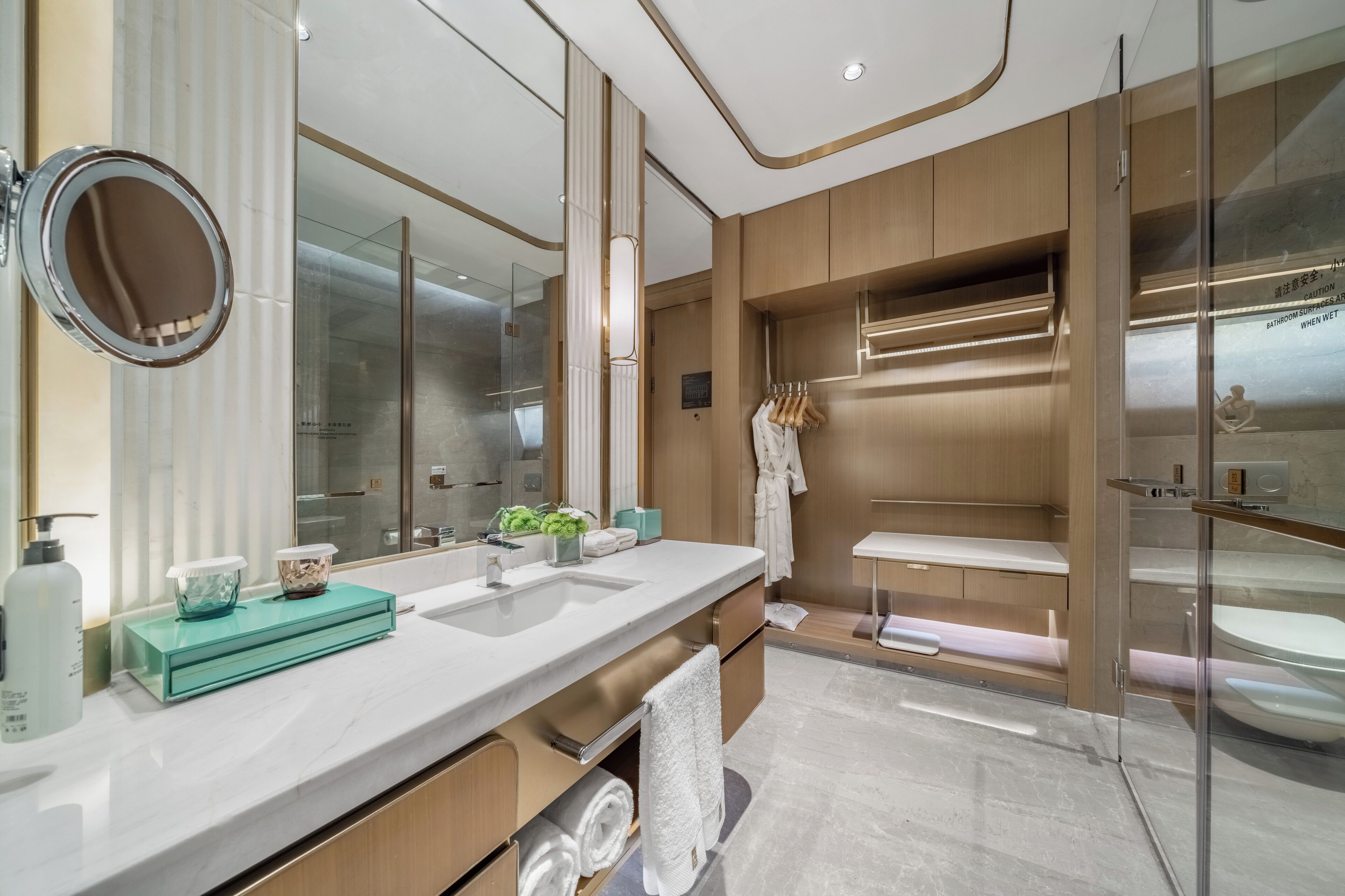 A modern bathroom with a large mirror, two sinks, and a glass-enclosed shower area.