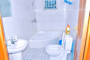 A bathroom with a white sink, a toilet, and a bathtub.