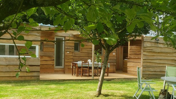 Una cabaña de madera con comedor, una mesita y una silla.