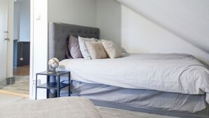 Une chambre à coucher avec un grand lit, une table de chevet et une commode.