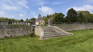 A stone staircase leading to a building with a stone wall and a clear sky.