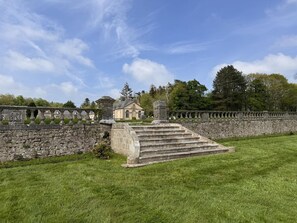 A stone staircase leading to a building with a stone wall and a clear sky.