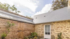 A stone building with a wooden door and a small window.