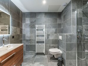 Enjoy a calm and inviting bathroom with a large mirror, sink, and walk-in shower.