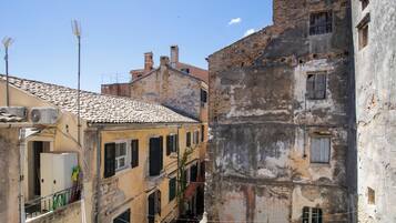 A narrow street with old buildings, some with balconies and visible wear.