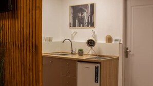 Une cuisine compacte équipée d’un lave-vaisselle intégré, d’un évier et d’un petit plan de travail.