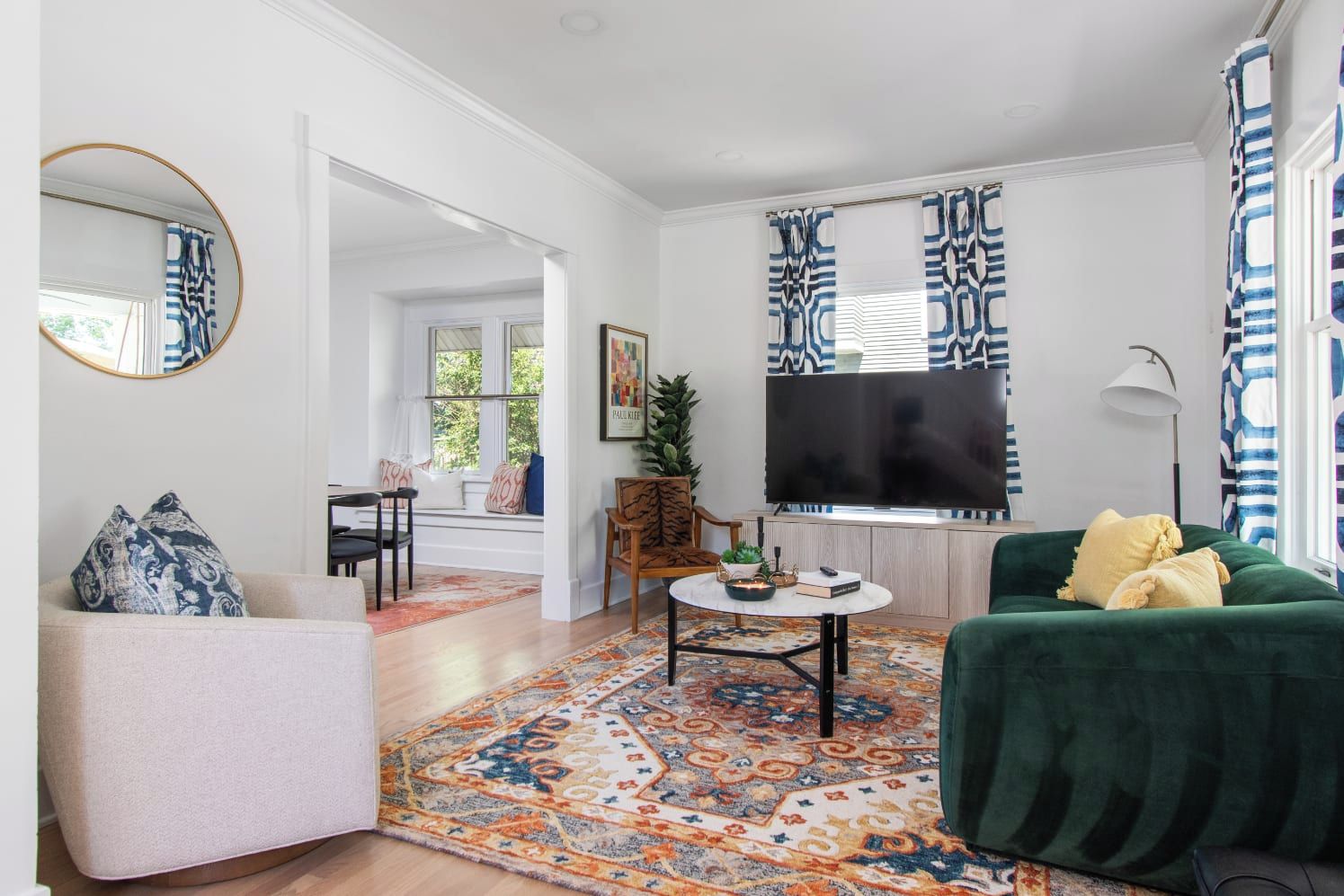 A living room with a sofa, a coffee table, a TV, and a patterned rug.