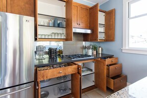 Una cocina moderna con armarios de madera, electrodomésticos de acero inoxidable y un ventanal que proporciona luz natural.