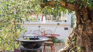 An outdoor seating area with a round table, chairs, and a fire pit. - Domaine Secret d'Uzès & Spa: Le Duché, with a heated swimming pool (Aubussargues)