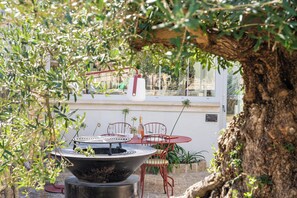 An outdoor seating area with a round table, chairs, and a fire pit.